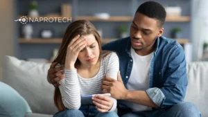Pareja preocupada observando una prueba de embarazo, representando el impacto del estrés en la fertilidad femenina, con el logo de Naprotech al fondo.